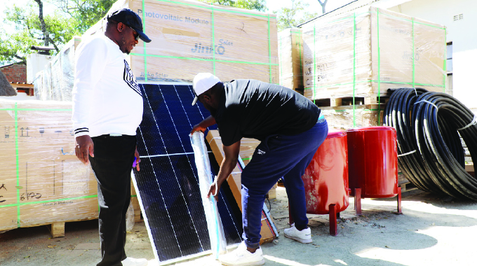 Prevail Group International chairman Tempter Tungwarara (left) inspects a consignment of solar powered boreholes accessories in Harare on Saturday