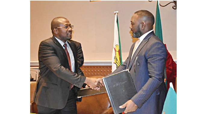 Environment, Climate, Tourism and Hospitality Industry Minister ,Mangaliso Ndlovu (left) shakes hands with his Zambian counterpart, Minister Rodney Sikumba in Livingstone, Zambia on Friday
