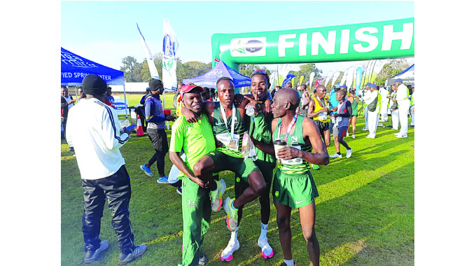 SERIAL WINNER... Moses Tarakinyu is hoisted by fellow athletes as he celebrates his latest win at the Tanganga Tea Half Marathon at Mutare Sports Club yesterday.