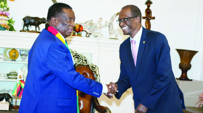 The President greets Reverend Bakary Camara (right) from the Family Federation for World Peace & Unification at State House in Harare yesterday.
