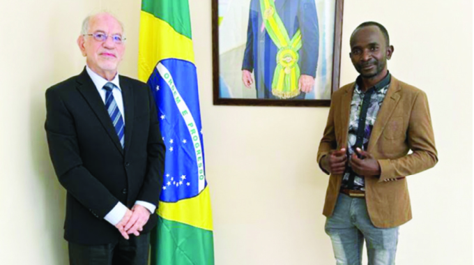 Brazilian Ambassador to Zimbabwe Vilmar R Coutinho JR poses with visual artist Raphael Jamu after a meeting at the embassy