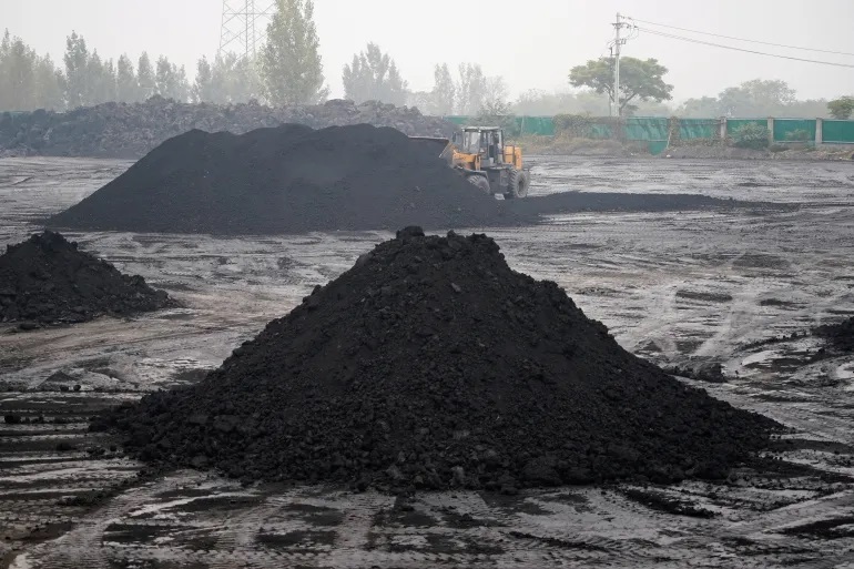 An excavator sifts through dunes of low-grade coal near a coal mine in Pingdingshan, Henan province, China [File: Aly Song/Reuters]