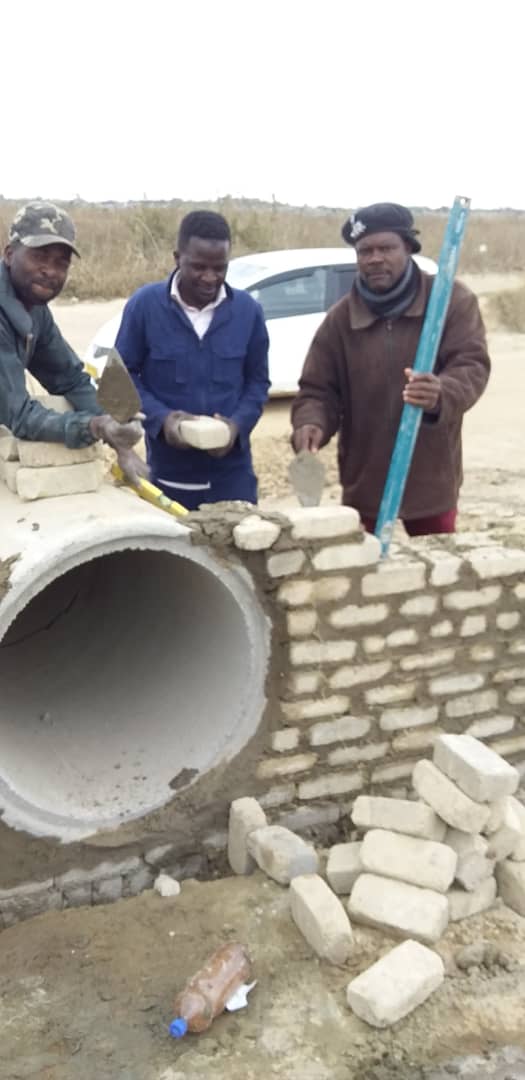 Councillor Mapuranga (right) building a small bridge in Nyatsime with the help of residents