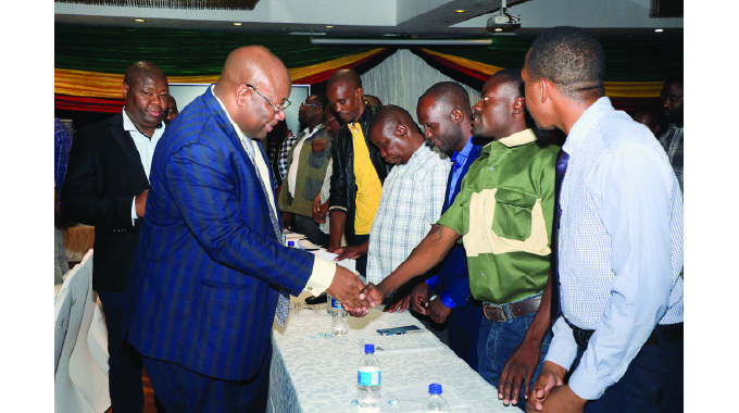 Local Government and Public Works Minister Winston Chitando accompanied by his permanent secretary Dr John Basera (in the background) greets Wedza Rural District Council acting planner Braston Kanyandura (second from right) while other delegates look on at an induction workshop for local authorities’ town planners in Harare yesterday.
