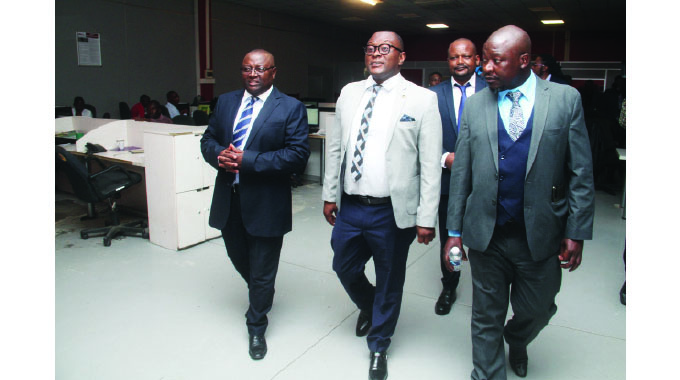 Information, Publicity and Broadcasting Services Minister Dr Jenfan Muswere (centre) is led into the newsroom by Alpha Media Holding (AMH), Kenias Mafukidze (left) and print manager, Taurai Matambo (right) during a familiarisation tour of the offices in Harare yesterday.