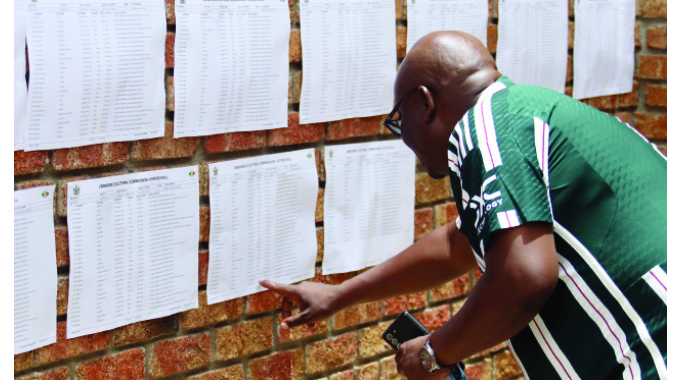 Zanu-PF aspiring candidate for Pelandaba Tshabalala constituency Cde Joseph Tshuma inspects the voters roll before casting his vote at Sizane High school yesterday