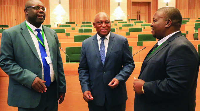 Reserve Bank of Zimbabwe Governor Dr John Mushayavanhu (centre), exchanges notes with chairperson of the Parliamentary Portfolio Committee on Budget, Finance and Economic Development Mr Clemence Chiduwa (left) and chairperson of the Portfolio Committee on Industry and Commerce Mr Ngonidzashe Mudekunye at the New Parliament Building in Harare, yesterday. — Picture: Kudakwashe Hunda